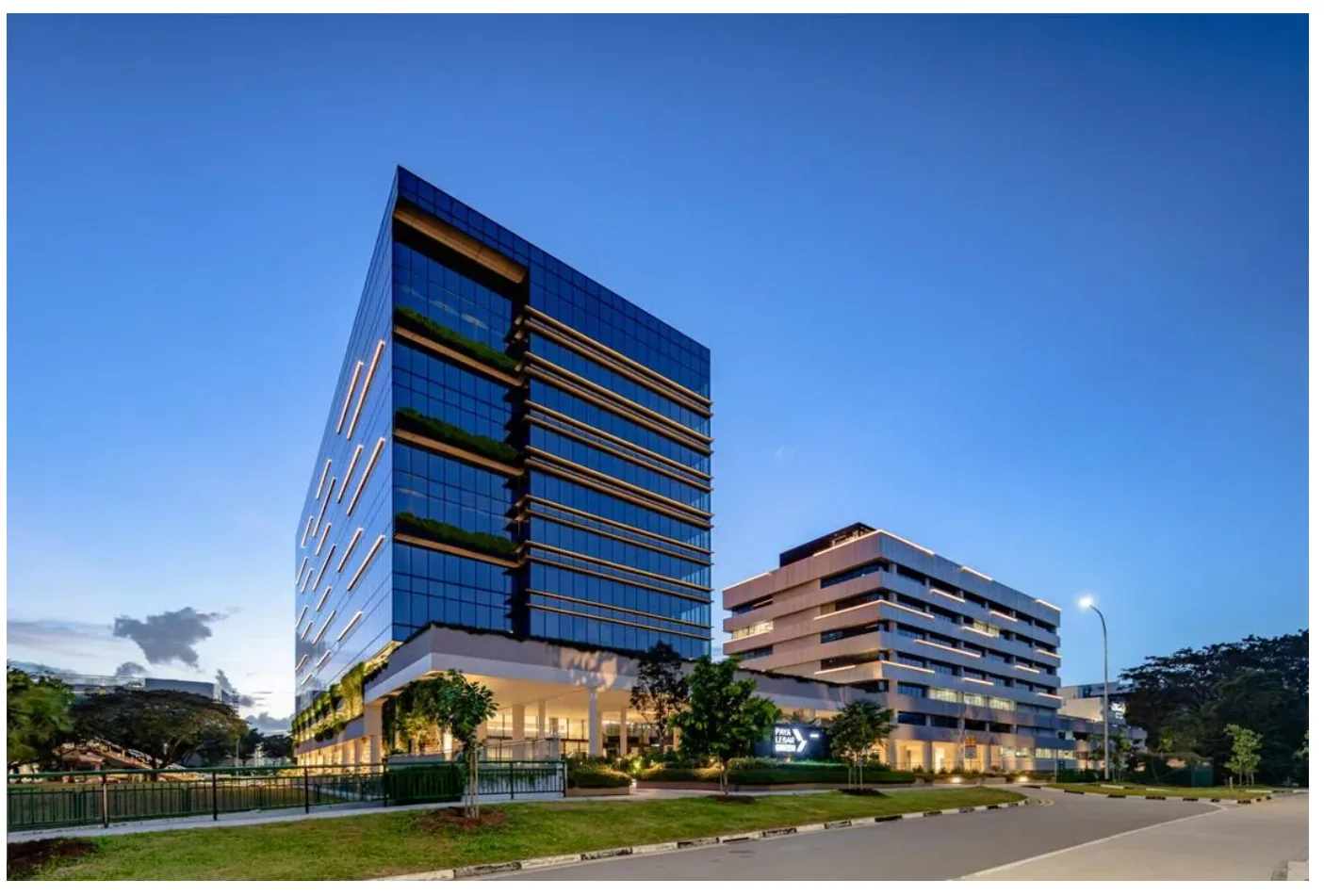 Paya Lebar Green office development at dusk, with deep planted terraces on its facade